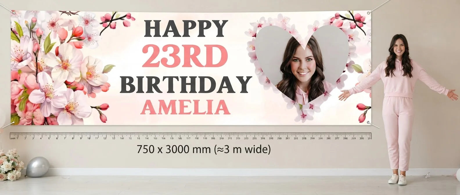 Person standing beside the Cherry Blossoms Birthday Party Banner for scale, with size guide showing 750 x 3000 mm
