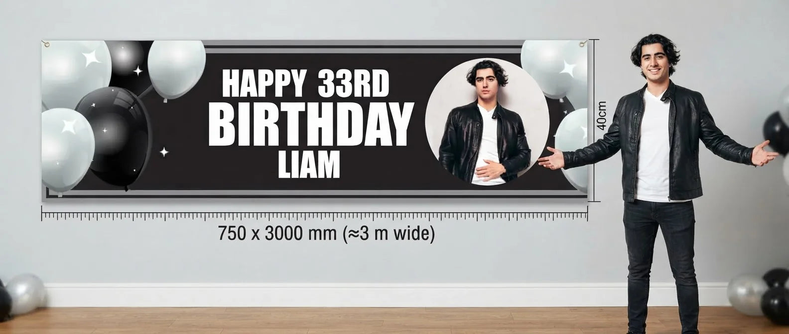 Person standing beside the Black and White Theme Birthday Party Banner for scale, with size guide showing 750 x 3000 mm