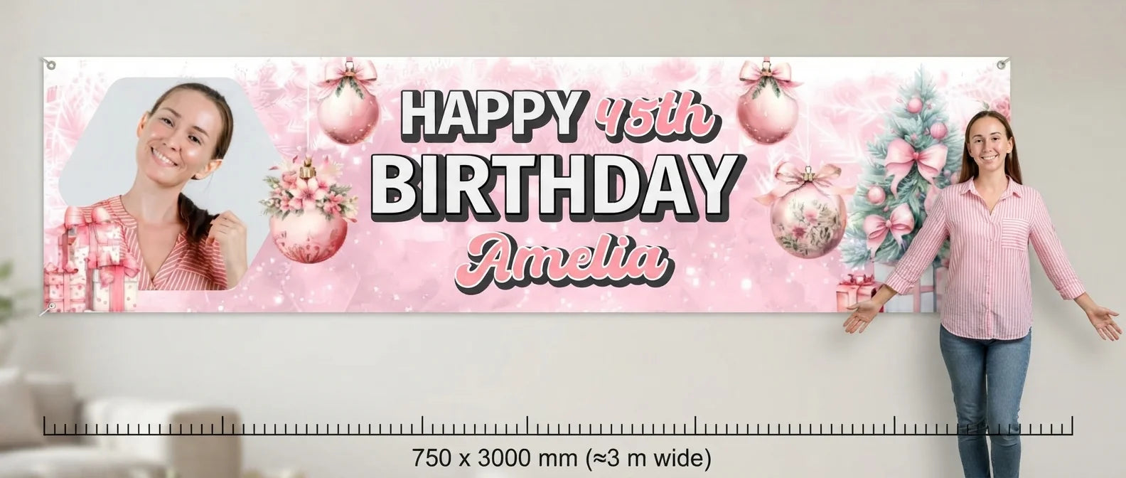 Person standing beside the Pink Christmas Birthday Party Banner for scale, with size guide showing 750 x 3000 mm