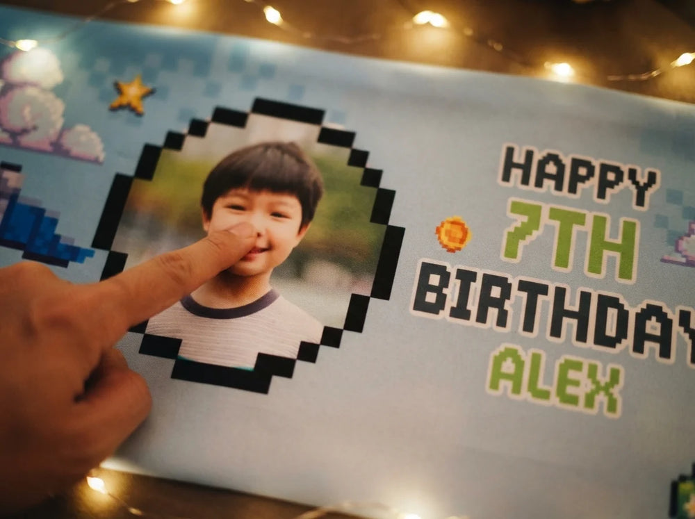 Close-up of the personalised name and photo printed on the 90s Game Pixel Birthday Party Banner