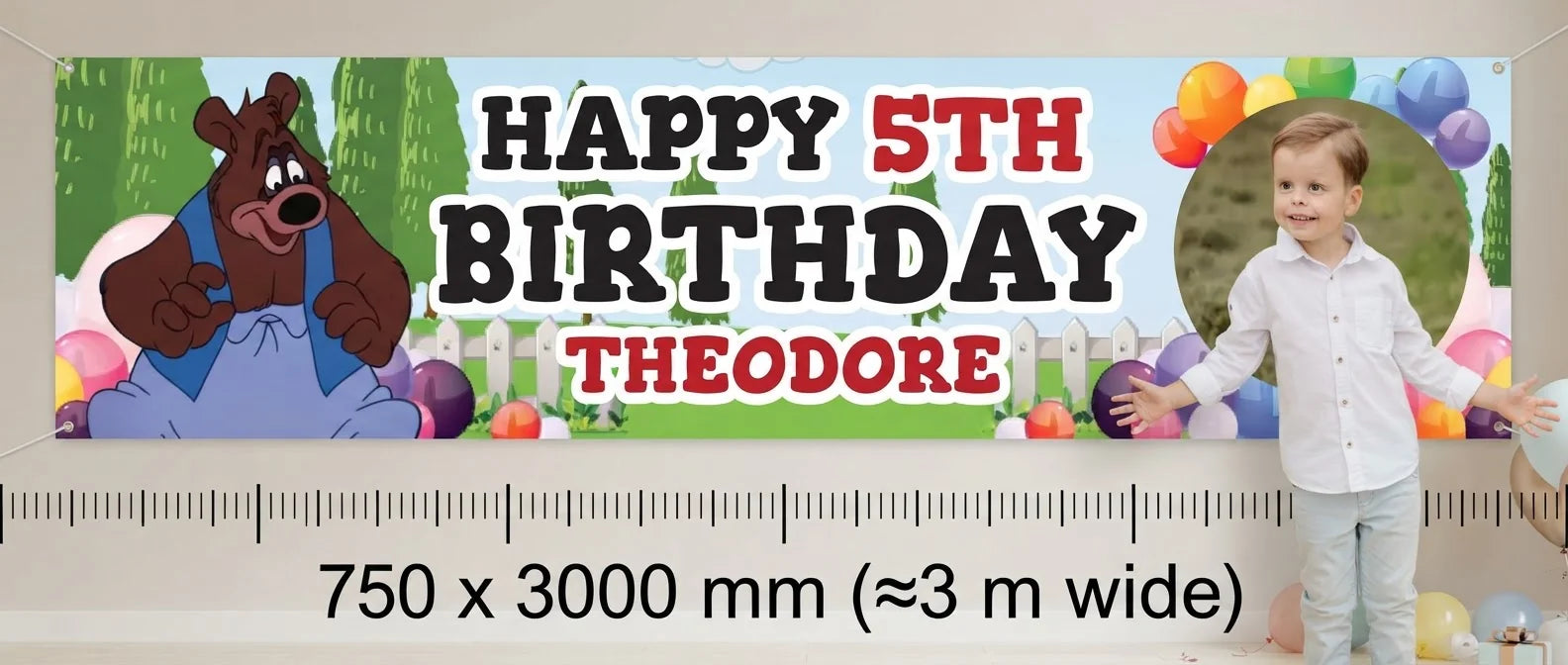 Person standing beside the Barney Bear Birthday Banner for scale, with size guide showing 750 x 3000 mm