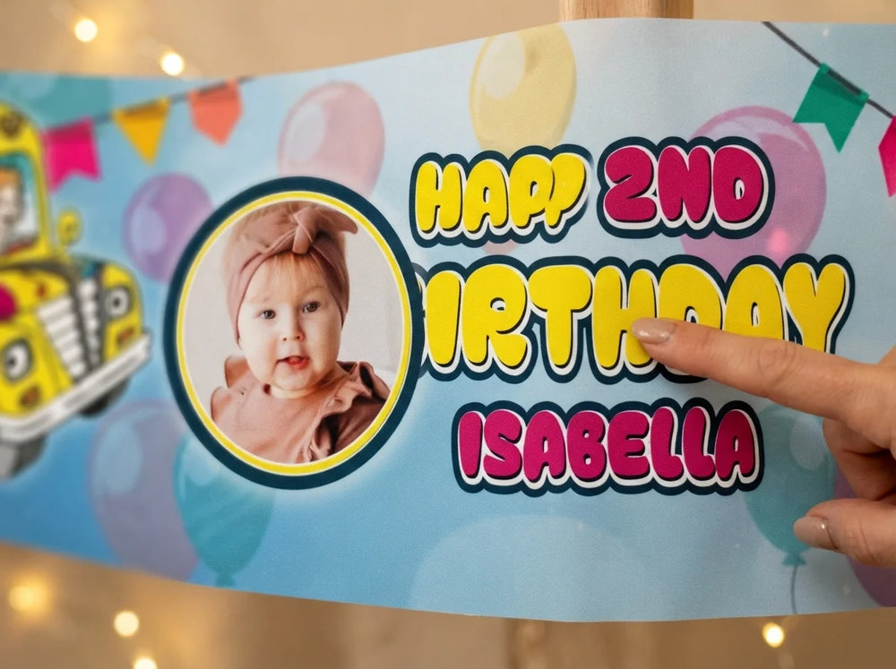 Close-up of the personalised name and photo printed on the Magic School Bus Birthday Banner