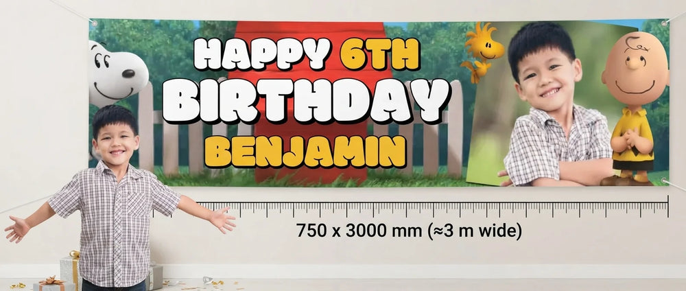 Person standing beside the Snoopy Birthday Banner for scale, with size guide showing 750 x 3000 mm